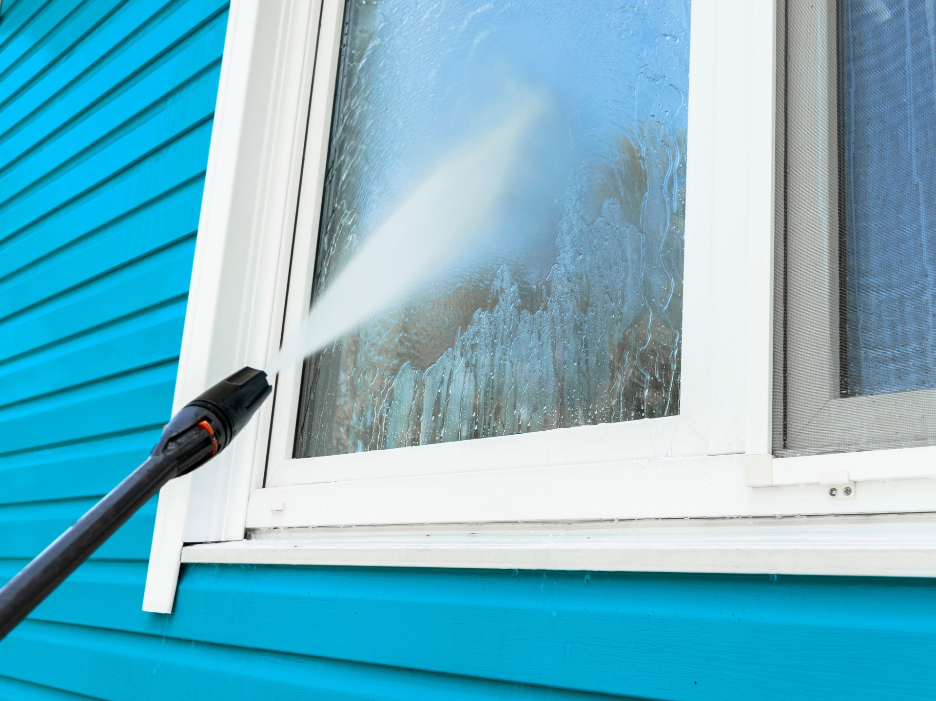 Cleaning service washing building facade and window with pressure water. Cleaning dirty wall with high pressure water jet. Power washing the wall. Cleaning the facade of the house. Before and after washing